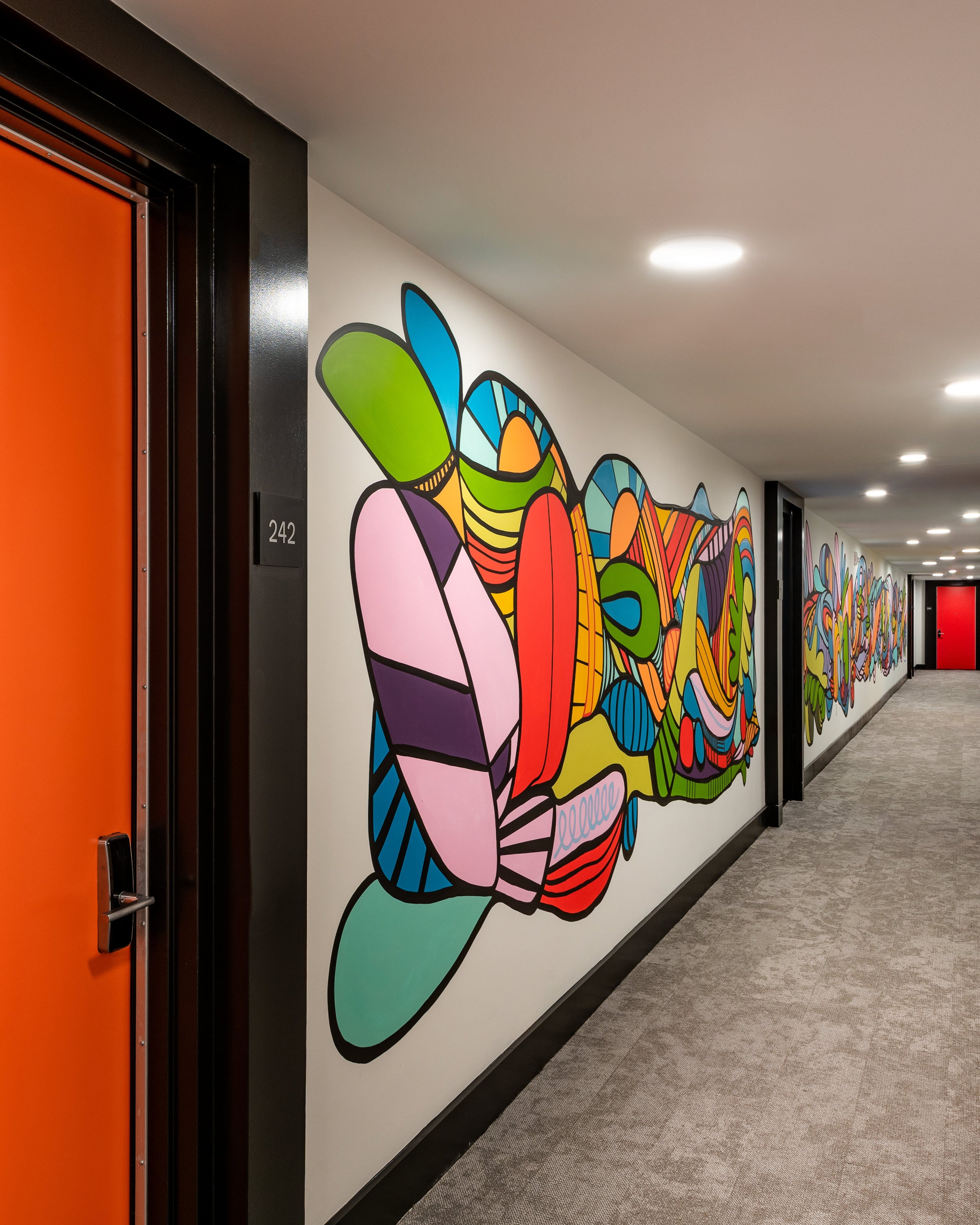 Rose Jaffee colorful graffiti-style mural covering hotel hallway wall, hospitality art installation by Morton Contemporary Art Advisory